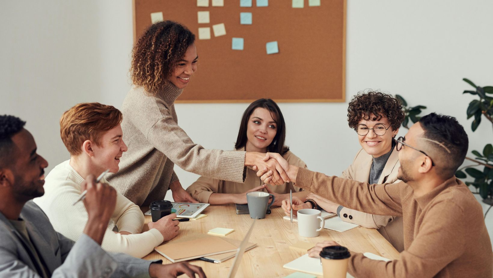 Team celebrates successful meeting with handshake.