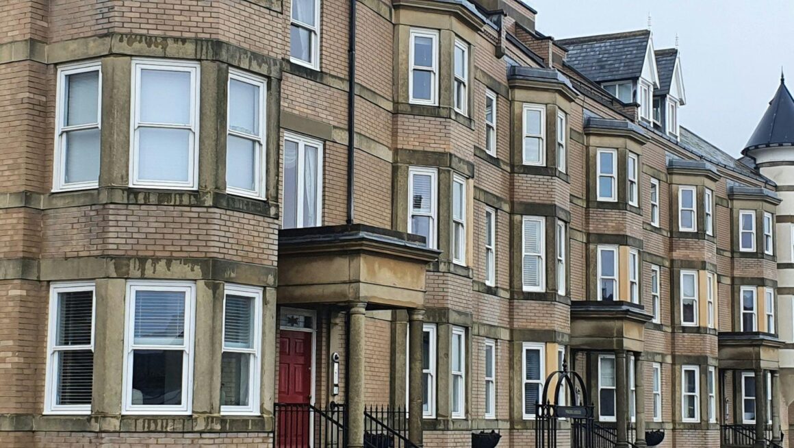 A row of typical British brick terraced houses of the kind often bought as buy-to-let rentals.